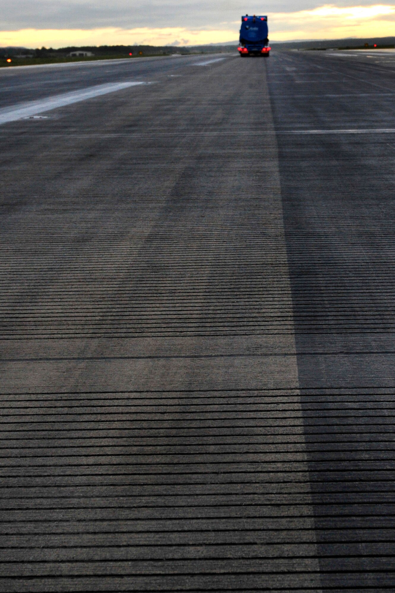 Contractors from Strate Wasserhochdrucktechnick e.K. remove excess rubber deposits from the runway to prevent aircraft from sliding off when they land, July 19, 2011, Ramstein Air Base, Germany.  The weeklong project cost $91K.  (U.S. Air Force Photo by Tech. Sgt. Chenzira Mallory)