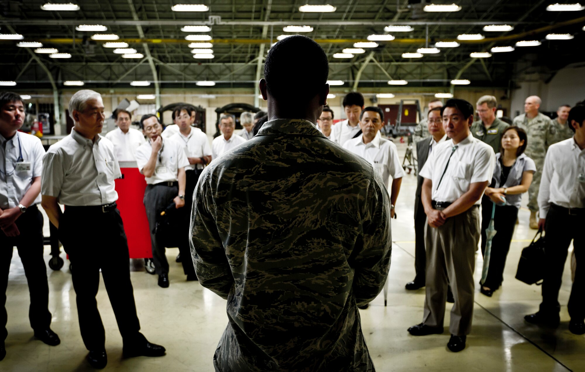 YOKOTA AIR BASE, Japan -- 2nd Lt. Steven Clark, 374th Maintenance Squadron Propulsion Flight commander, gives local dignitaries a tour of his work center at Yokota Air Base, Japan, July 19, 2011. Each quarter, Yokota hosts vice mayors from the six surrounding communities as well as leaders from the Tokyo Metropolitan Government, North Kanto Defense Bureau and Yokota Defense Office to discuss local concerns and strengthen ties between the base and its neighbors. (U.S. Air Force photo/Staff Sgt. Samuel Morse)