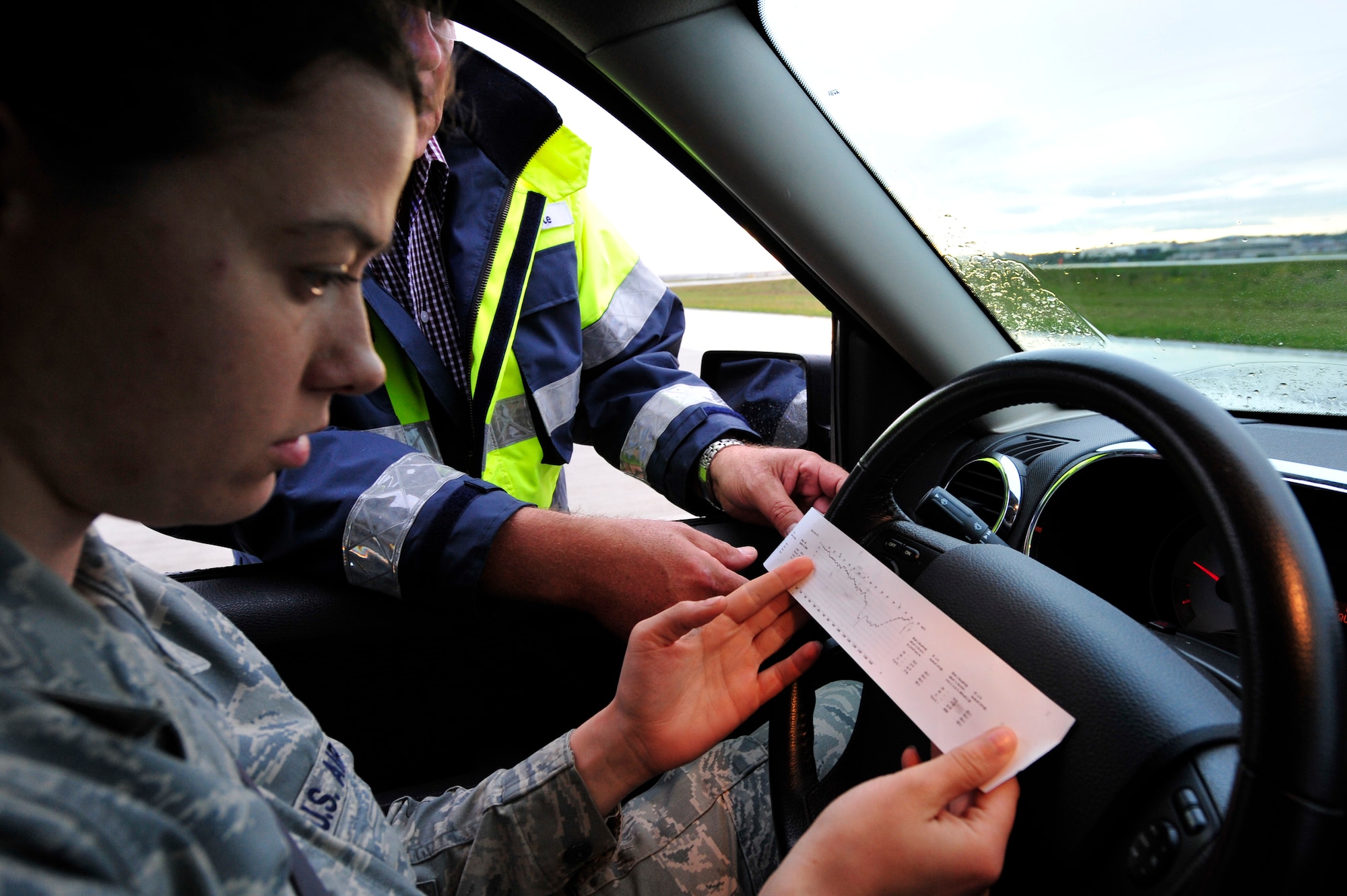 Mr. Reinhard Strate, Strate Wasserhochdrucktechnick e.K. general manager, reviews the results of a friction test with U.S. Air Force Staff Sgt. Stephanie Heck, Airfield Management Operations NCOIC, prior to cleaning the runway, July 19, 2011, Ramstein Air Base, Germany.  Contractors from Strate removed excess rubber from various parts of the runways to prevent aircraft from sliding when they land.  The weeklong project cost $91K.  (U.S. Air Force Photo by Tech. Sgt. Chenzira Mallory)