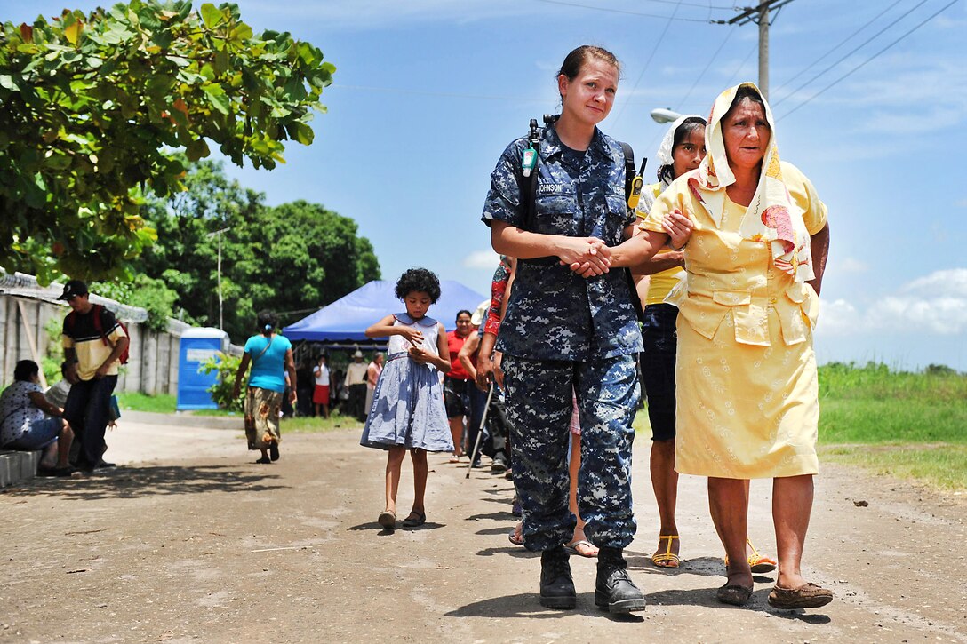 U.S. Navy Petty Officer 2nd Class Amanda Johnson assists a Salvadoran woman during a Continuing Promise 2011 community medical event at the Polideportivo medical site in Acajutla, El Salvador, July 19, 2011. Johnson is a Hospital Corpsman. Continuing Promise is a five-month humanitarian assistance mission to the Caribbean, Central and South America.