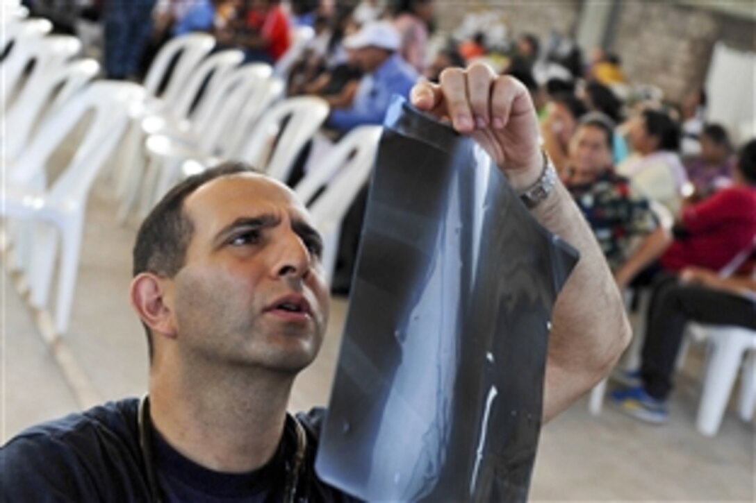 U.S. Navy Cmdr. Michael Monsour reviews a patient's X-ray during a Continuing Promise 2011 community medical event at the Polideportivo medical site in Acajutla, El Salvador, July 19, 2011. Continuing Promise is a five-month humanitarian assistance mission to the Caribbean, Central and South America.