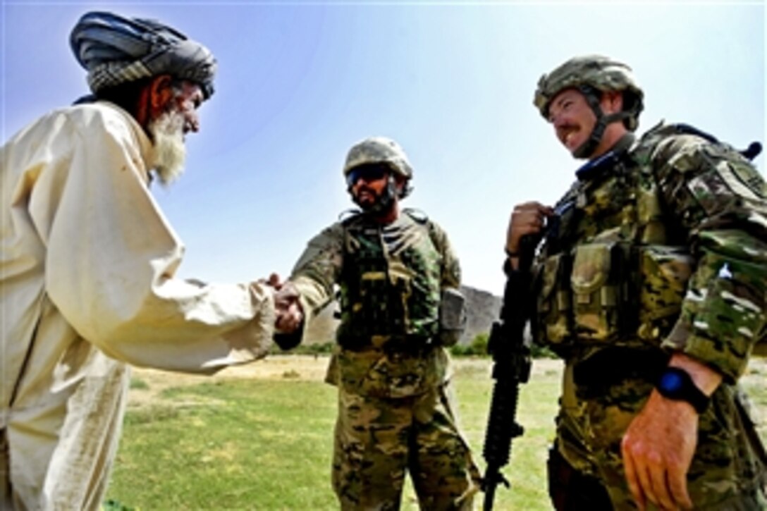 U.S. Army 1st Lt. Benjamin Riley (right) and a Provincial Reconstruction Team Zabul interpreter (center) meet a villager during a patrol to the Arghandab River, Afghanistan, on July 19, 2011.  Riley is a civil affairs officer assigned to the team's security force and is deployed from the Massachusetts National Guard.  The team's mission is to conduct civil-military operations in Zabul province to extend the reach and legitimacy of the Afghan government.  