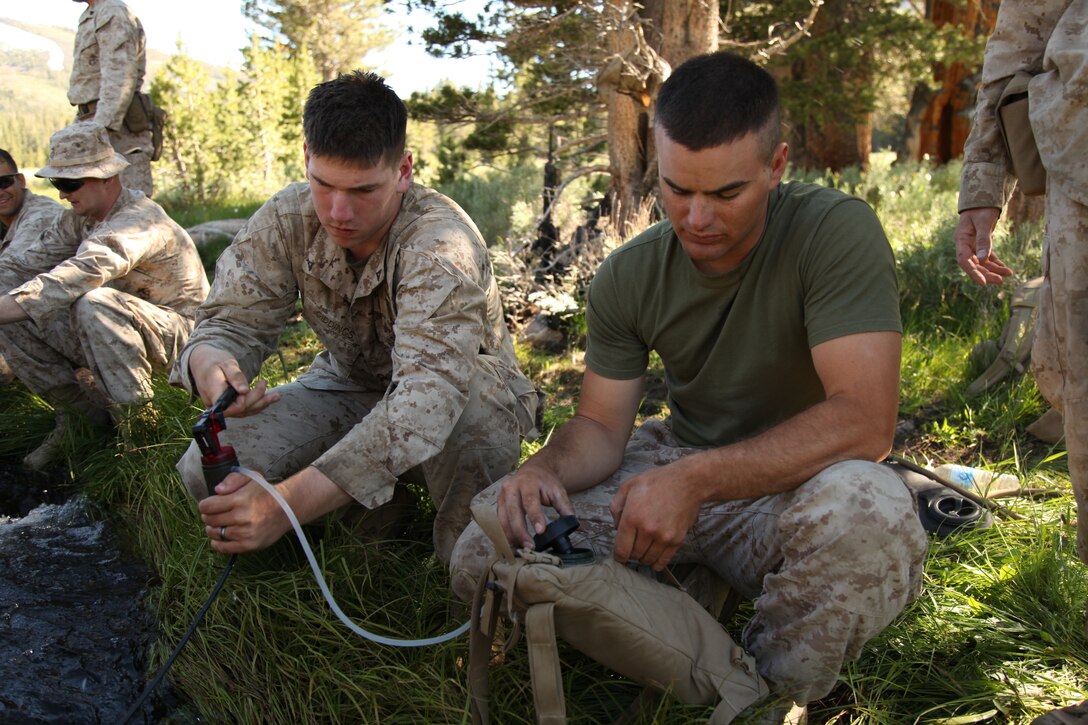 Lance Cpl. Blain Giddings, a Papillion, Neb., native and Lance Cpl. Thomas Leach, an Armstrong, Iowa, native, operate a water purification system, July 20. The Marines took time to learn these skills, passed down by the unit’s Mountain Warfare Leader’s Course graduates, as they settled into their new home at the MWTC.