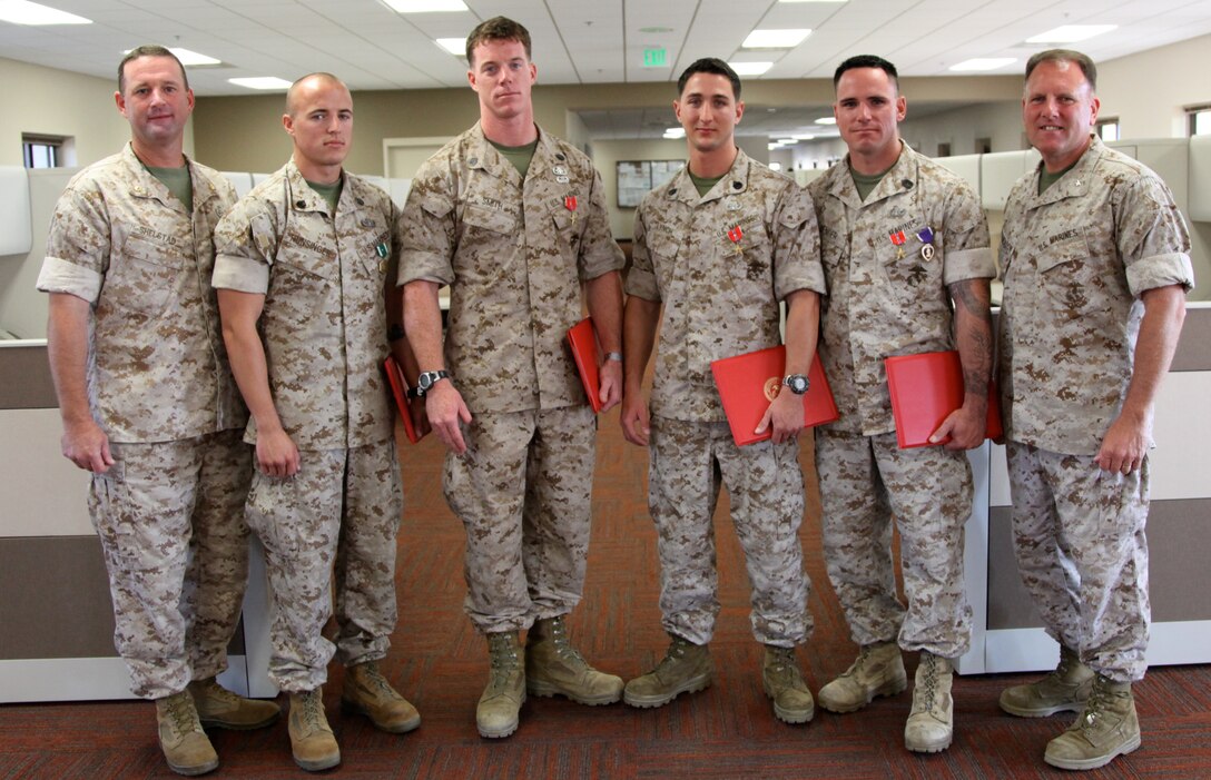 Four Marines from 1st Explosive Ordnance Disposal Company, 7th Engineer Support Battalion, Combat Logistics Regiment 1, 1st Marine Logistics Group, were recognized for bravery under fire in a ceremony at Camp Pendleton, Calif., July 20. Bronze Star Medals with combat distinguishing device were awarded to Gunnery Sgt. Donavin G. Bender, Staff Sgt. Timothy Lynch and Staff Sgt. Michael R. Smith. The Purple Heart Medal was awarded to Bender, and the Navy and Marine Corps Commendation Medal with combat distinguishing device was awarded to Staff Sgt. Kevin M. Hunsinger.::r::::n::