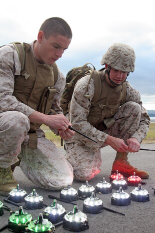Sgt. Esteban M. Ramirez (left) and Sgt. Matthew R. Kolenc, Marine Air Control Squadron 4 Detachment Bravo air traffic controllers, check to make sure lights function properly during the Marine Air Traffic Control Mobile Team training at the station flight line here July 21. The training called for the Marines to successfully set up an expeditionary runway for a C-130.