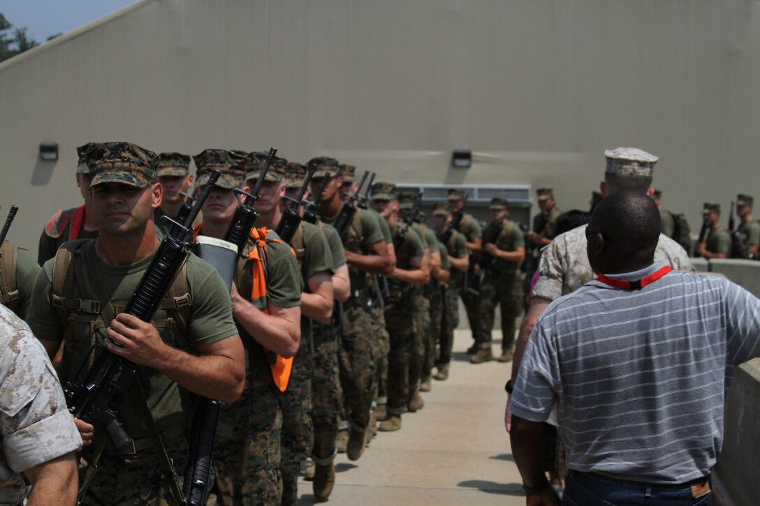 Officer candidates on their way to chow at Officer Candidate School here file past Dr. Legand Burge, Dean of Engineering, Tuskegee University, July 21. Burge was part of the Key Influencers Workshop, a week-long look at how the Marine Corps assesses and trains its officers.