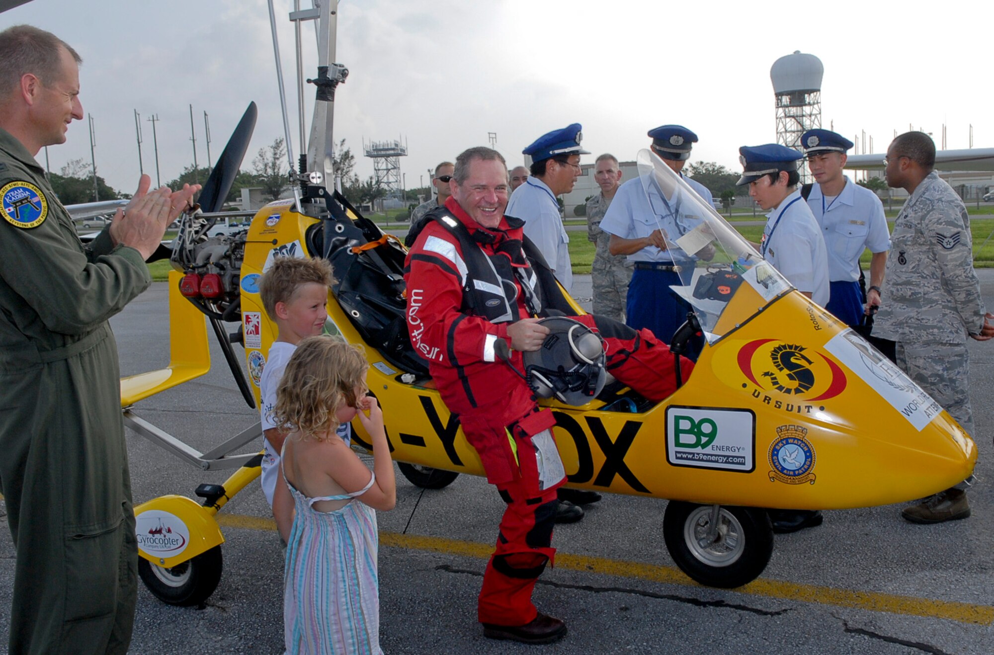 Col. Corey Martin, 18th Wing vice commander, applauds Norman Surplus, an autogyro pilot from Larne, County Antrim, Northern Ireland, as he steps out of his MT-03 autogyro, 'Roxy', after landing July 20 at Kadena Air Base, Japan. Surplus is making the first autogyro world record attempt at a circumnavigation of the globe.  "The 8.5-hour flight from the Philippines to Kadena was the longest and most demanding flight of the expedition because it was over water", said Martin "I only saw two ships during my flight." (U.S. Air Force photo/ Airman 1st Class Tara A. Williamson)