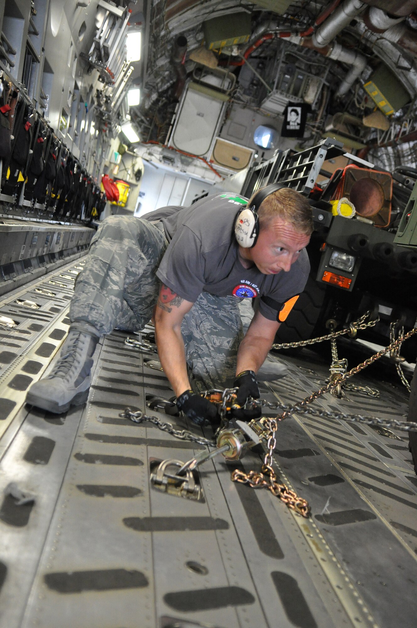 Staff Sgt. Mark Robertson, 62nd Aerial Port Squadron Rodeo Team member, tightens a chain to restrain a humvee aboard a C-17 Globemaster III during Rodeo training July 19 at Joint Base Lewis-McChord, Wash. The team has been preparing for Rodeo since May with daily training scenarios and early morning workouts. Rodeo, sponsored by the Air Mobility Command, is the Mobility Air Force's readiness competition. This competition focuses on improving worldwide air mobility forces' professional core abilities. (U.S. Air Force photo/Airman 1st Class Leah Young)