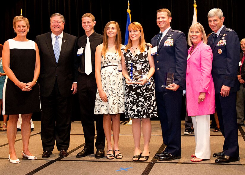 Secretary of the Air Force Michael Donley (second from left), his wife Gail (far left), Air Force Chief of Staff Gen. Norton Schwartz and his wife Suzie (second from right) congratulate the Arnold family for being recognized as the National Military Family Association's Air Force Family of the Year during a luncheon July 21, 2011, in Arlington, Va. The National Military Family Association chose the Arnold family, consisting of Maj. Eric Arnold, his wife Cristie, and their children Christian, Cierra and Conner (not pictured), for their commitment to community service. The Arnolds are stationed at Dyess Air Force Base, Texas. The association recognized families from each of the uniformed services, including the U.S. Public Health Service. (U.S. Army photo/Myles Cullen)