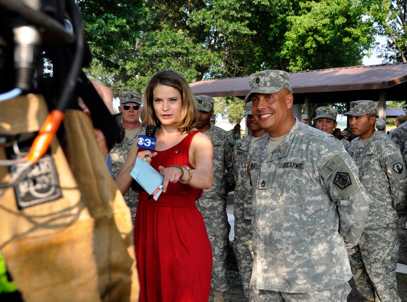 Erika von Tiehl, anchor for Philadelphia CBS 3, prepares to go on the air live with Army Sgt. 1st Class Luis Valle, part of the Army Liaison Team with the Charles C. Carson Center for Mortuary Affairs, during a Star Spangled Barbecue hosted by USO Delaware and CBS 3 July 20, 2011 at the Eagles Nest picnic area at Dover Air Force Base, Del. (U.S. Air Force photo/Staff Sgt. Agustin Salazar)