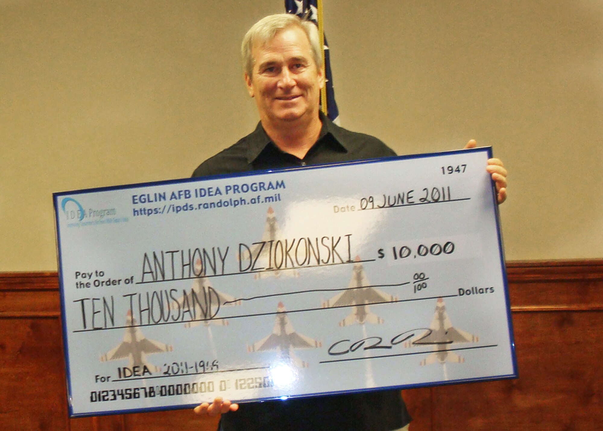 Anthony Dziokonski holds his $10,000 check from the Air Force Innovative Development through Employment Awareness (IDEA) program. Dziokonski earned the money for his idea to use an incinerator to help the 46th Test Wing get rid of test materials used to detect direction and velocity of bomb explosion fragments. The burner consumes massive amounts of the wood waste quickly and minimizes the amount of pollutants released. (Courtesy photo)