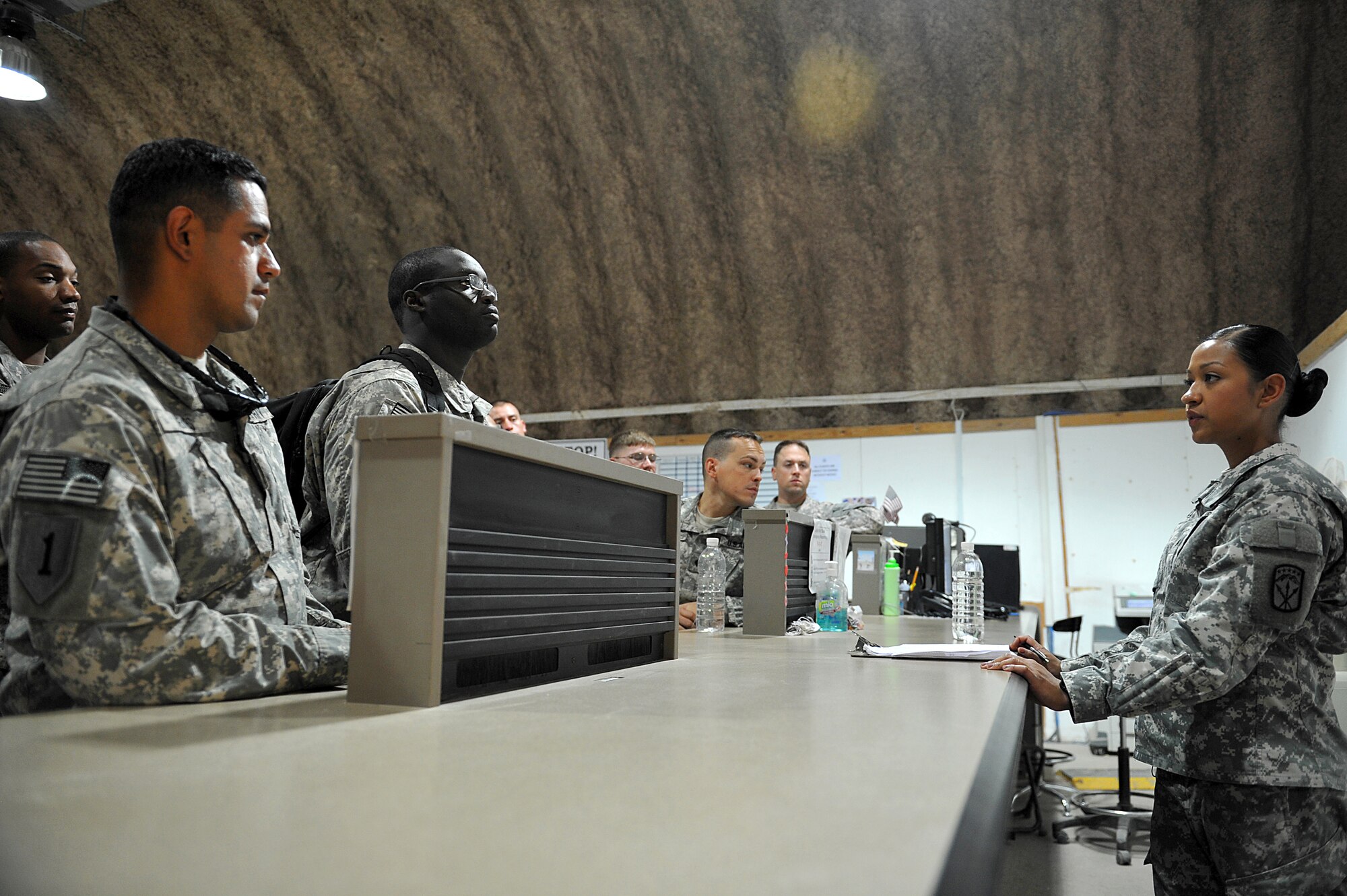 U.S. Army Sgt. Jessica Recinos, 22nd Human Resources Company, rest and relaxation customer service representative and passenger terminal clerk, informs passenger on flight information, as they prepare to leave for rest and relaxation, or R&R, Sather Air Base, Iraq, July 19, 2011. In addition to her assigned duties Recinos volunteers evenings leading a cycling spin class, keeping troops in shape. Recinos is deployed from Joint Base Lewis-McChord, Wash. and hails from Santa Anna, Calif. (U.S. Air Force photo/Tech. Sgt. Josef Cole)

