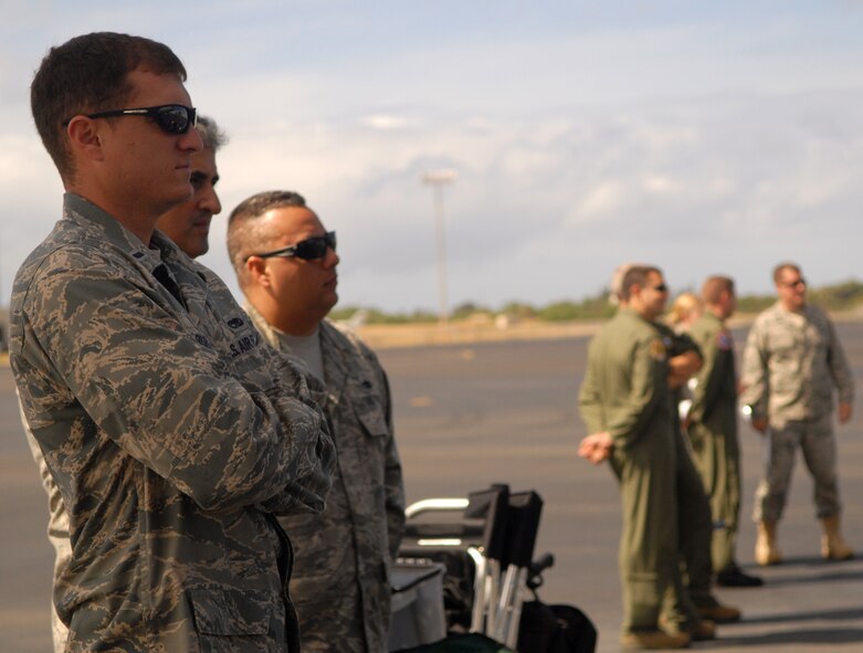 Airmen from Joint Base Pearl Harbor-Hickam watch as "Hawaii Five-0" films a portion of an upcoming episode on the flight line July 20. Ten Airmen participated in the shoot, doing their day-to-day jobs, and now have a chance to be in the final shots. The production supervisor said they try to include military servicemembers in scenes whenever possible. (U.S. Air Force photo/Staff Sgt. Carolyn Herrick)

