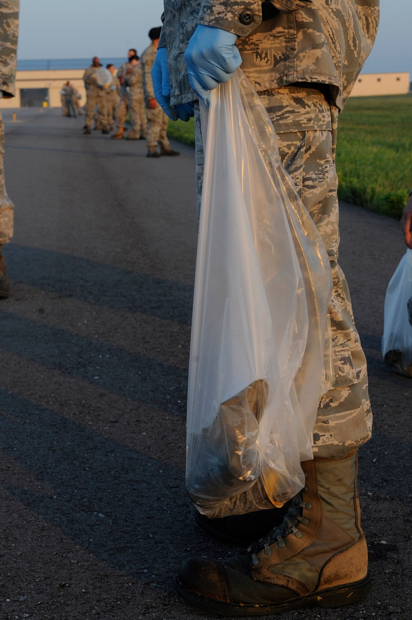 WHITEMAN AIR FORCE BASE, Mo. ? Members of Whiteman Air Force Base, Mo. performs a foreign object debris walk on the flightline collecting more than 200 pounds before starting the day, July 15. After Airmen perform their FOD walks, the collected debris is combined into one bag and turned in. At the end of each quarter, the total amount of FOD collected is weighted. (U.S. Air Force photo by Senior Airman Alexandra M. Boutte) (RELEASED)