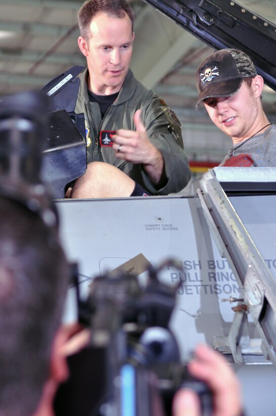 While a cameraman films a public service announcement, Maj. Mike Barron, left, shows off an F-16 Fighting Falcon to the 2011 winner of the American Idol television show, Scott McCreery, July 20, 2011.  Major Barron is an Air Force Reserve F-16 pilot in the 457th Fighter Squadron, part of the 301st Fighter Wing, based at NAS Fort Worth JRB, Texas.  Air Force Reserve Command Recruiting Service is sponsoring the American Idol national tour to market the Air Force Reserve to young men and women.  (U.S. Air Force photo/Lt. Col. David Kurle)