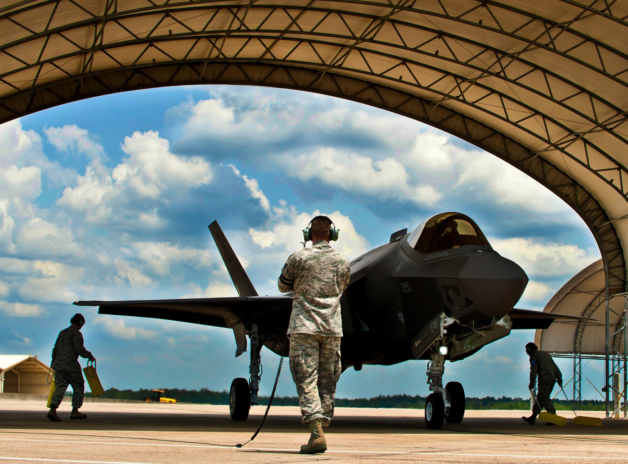 33rd Aircraft Maintenance Squadron maintainers bring out chocks to secure the newly arrived second F-35 Lightning II joint strike fighter at Eglin Air Force Base, Fla., July 20.  The pilot, Maj. Joseph Bachmann, of the 33rd Operations Group, is the first Marine pilot to be JSF certified. Aircraft AF-8 is the flagship for the 58th Fighter Squadron.  (U.S. Air Force photo/Samuel King Jr.)