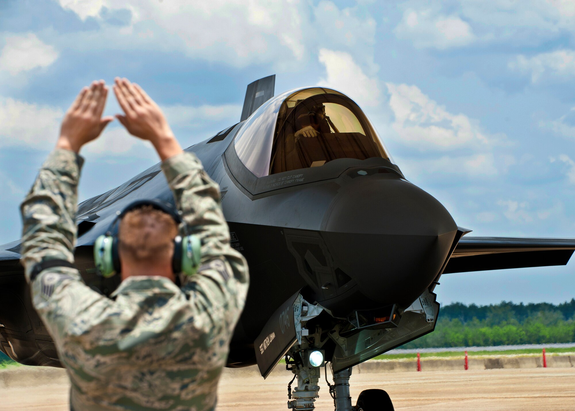Staff Sgt. Matthew Lohman, of the 33rd Aircraft Maintenance Squadron, marshals in the second F-35 Lightning II joint strike fighter to arrive at Eglin Air Force Base, Fla., July 20.  The pilot, Maj. Joseph Bachmann, of the 33rd Operations Group, is the first Marine pilot to be JSF certified. Aircraft AF-8 is the flagship for the 58th Fighter Squadron.  (U.S. Air Force photo/Samuel King Jr.)