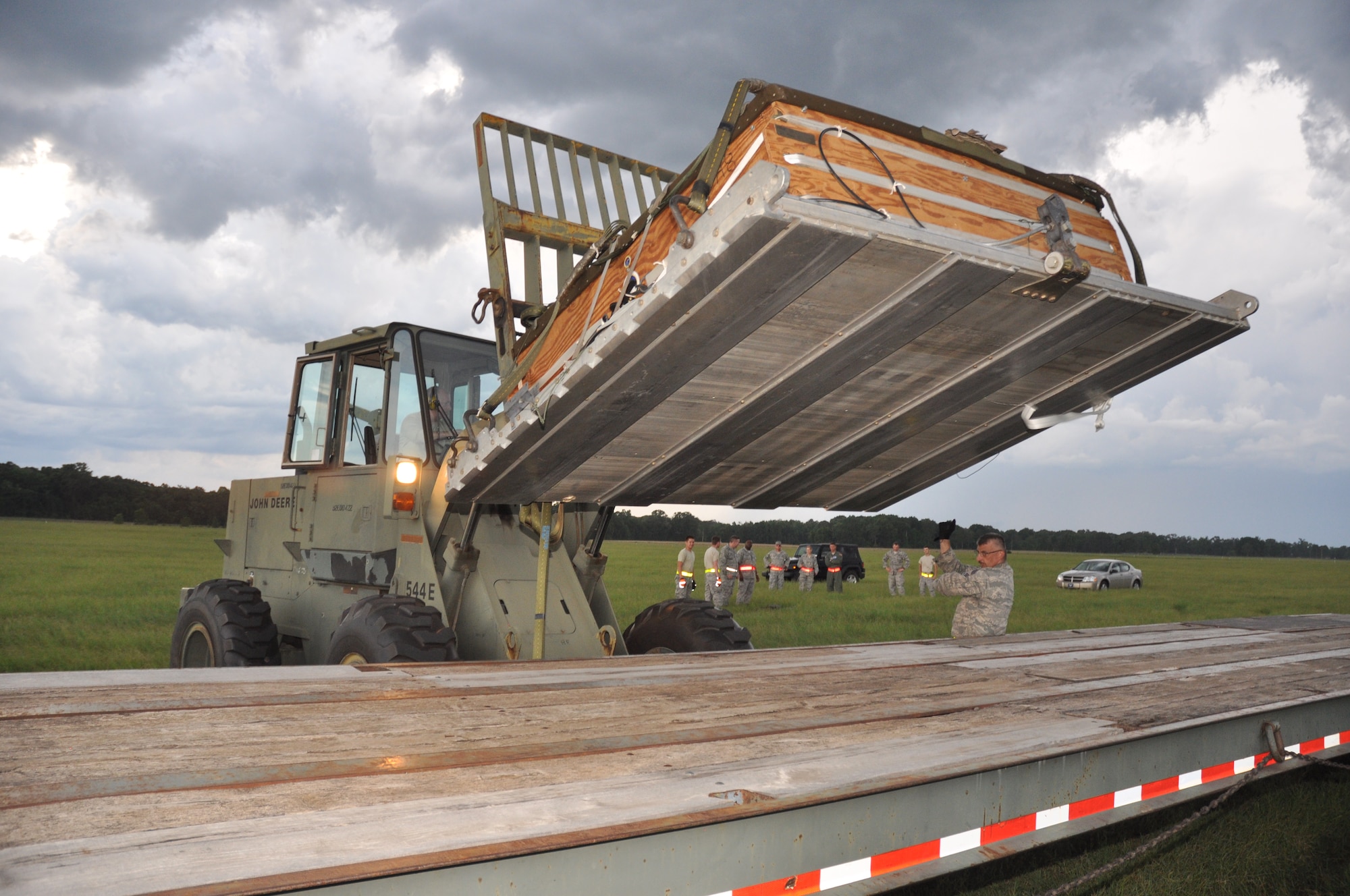 Chief Master Sgt. Harold Whited of the 25th Aerial Port Squadron guides a forklift loading a training platform on a flatbed during the recent TAC weekend.