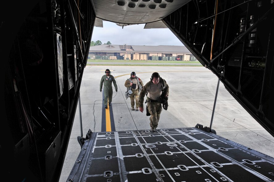 U.S. Air Force Tech. Sgt. Alfert Anderson, 71st Rescue Squadron loadmaster, greets pararescuemen Master Sgt. Robert Disney , 347th Rescue Group, and Tech. Sgt. Mark panzer, 38th Rescue Squadron, onto an HC-130 Combat King at Moody Air Force Base, Ga., July 12, 2011. The pararescuemen performed a tandem and free fall jump during a training mission. (U.S. Air Force photo by Senior Airman Stephanie Mancha/Released)