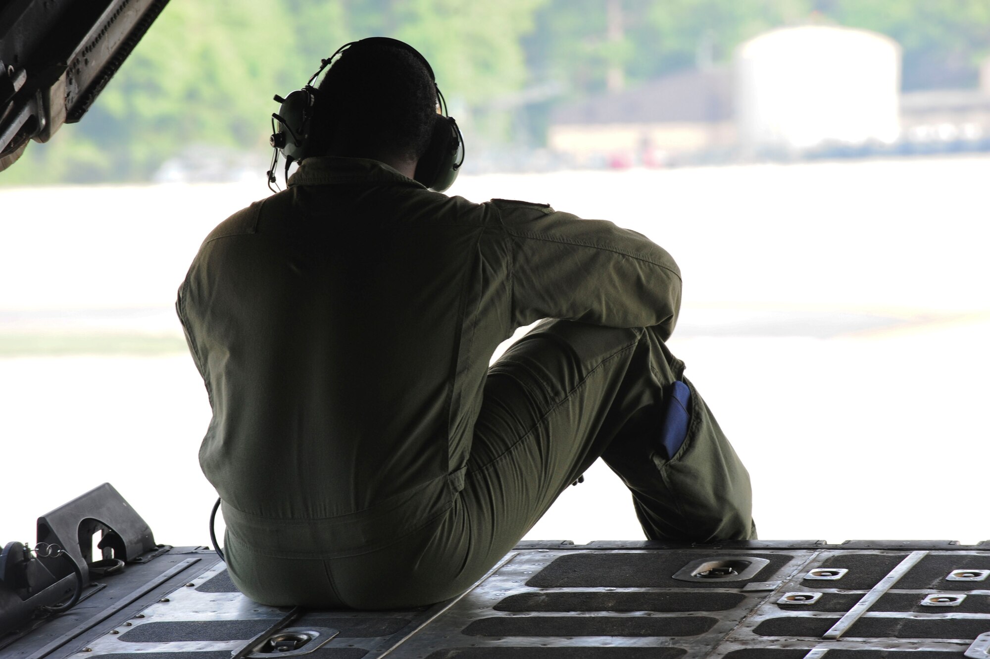 U.S. Air Force Tech. Sgt. Alfert Anderson, 71st Rescue Squadron loadmaster, sits on the edge of an HC-130 Combat King cargo door at Moody Air Force Base, Ga., July 12, 2011. Before taking off, the aircraft taxied to pick up two pararescueman who were scheduled to perform a tandem and free fall jump.  The operation served as training for both the aircrew and pararescuemen. (U.S. Air Force photo by Senior Airman Stephanie Mancha/Released)