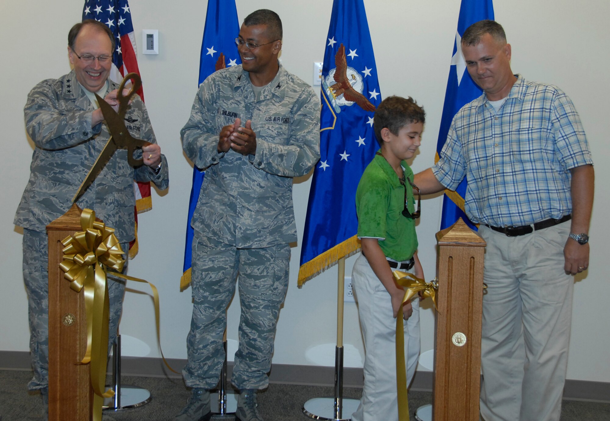 Lt. Gen. Charles E. Stenner Jr., left, commander of Air Force Reserve Command, and Col. Joe N. Wilburn, commander of AFRC Recruiting Service, share a chuckle about the over-sized scissors used to cut the ribbon dedicating recruiting’s new building on Robins Air Force Base, Ga., July 15, 2011. Staff Sgt. Christopher Earl Johnson, right, and his son helped cut the ribbon dedicating the building. Johnson enlisted in the Air Force Reserve before the ceremony as a traditional reservist in the 55th Combat Communications Squadron at Robins AFB. A former Marine, Johnson is a self-employed roofer in civilian life. (U.S. Air Force photo/Claude Lazzara)


