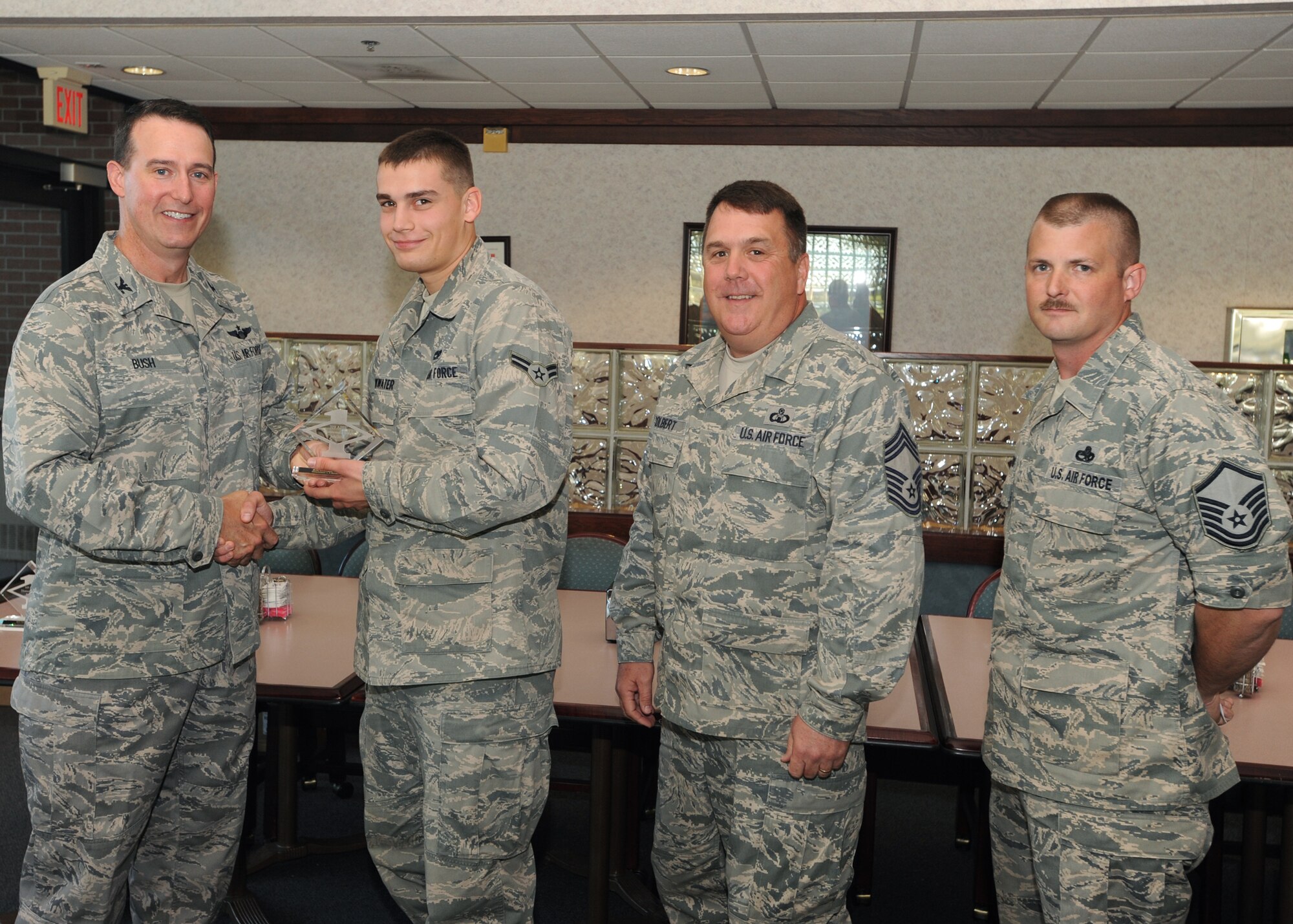 Col. Tim Bush, 319th Air Base Wing commander, presents Airman 1st Class Brandon Drinkwater, Detachment 1, with a Diamond Sharp Award July 21 at Airey Dining Facility here, accompanied by Chief Master Sgt. Donald Colbert, 319th Operations Support Squadron, and Master Sgt. Brian Dipersio, Det.1 acting first sergeant. The Diamond Sharp Award is given to those Airmen who epitomize service before self and strive for excellence at work and off duty. (U.S. Air Force photo by Staff Sgt. Suellyn Nuckolls)