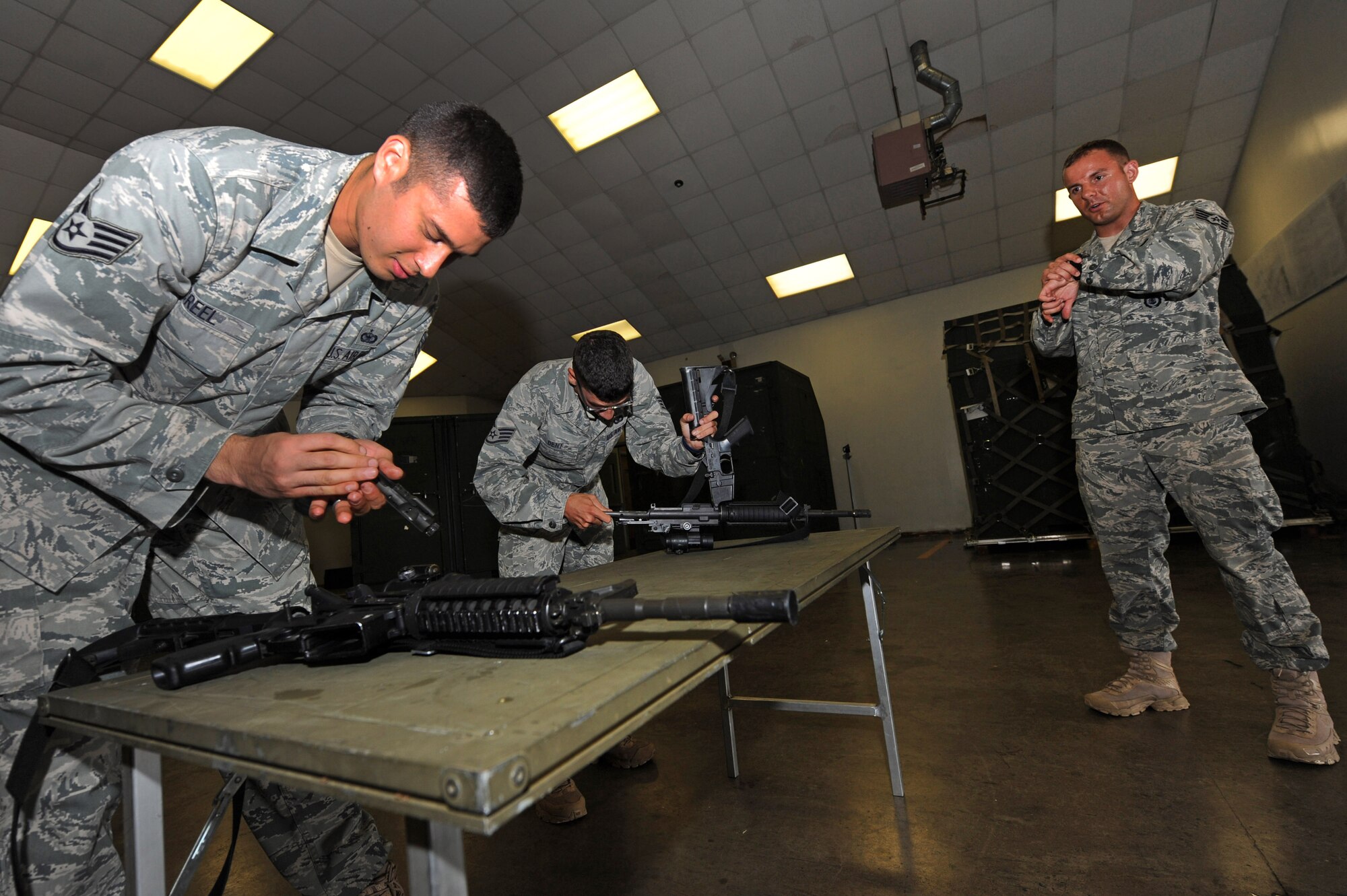 Staff Sgt. Gregory Creel, 19th Security Forces Squadron quality control, and Staff Sgt. Patrick Dent, a 19th SFS alpha flight desk sergeant, race to disassemble an M-4 carbine while being timed by Staff Sgt. Carl Hooks, a 19th SFS security forces trainer, July 13, 2011, at Little Rock Air Force Base, Ark. The 19th SFS RODEO team is currently training to compete in the Air Mobility Command RODEO 2011, held at McChord Field on Joint Base Lewis-McChord, Wash., from July 24 to July 29. (U.S. Air Force photo by Tech. Sgt. Chad Chisholm