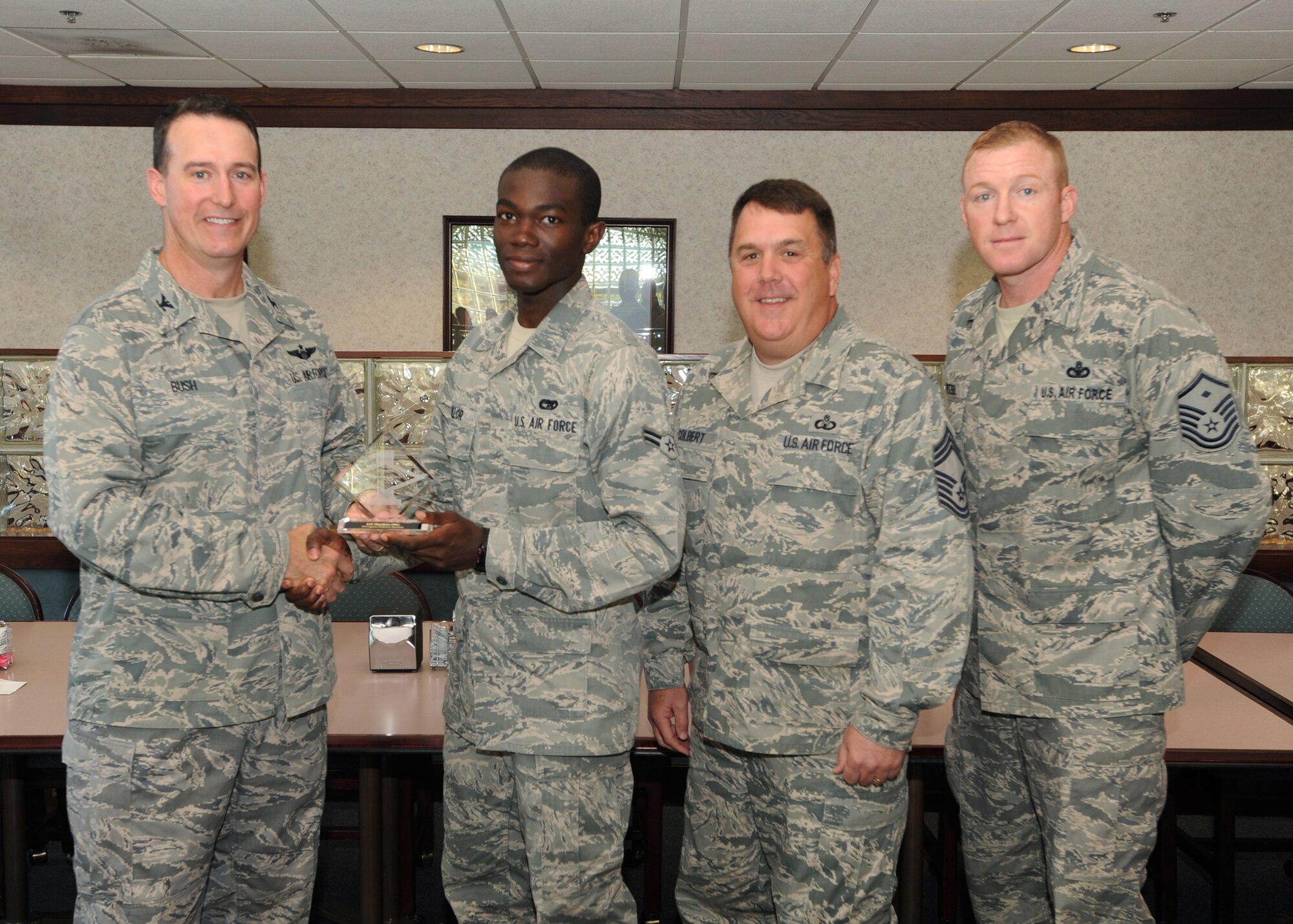 Col. Tim Bush, 319th Air Base Wing commander, presents Airman 1st Class Obarijima Ollor, 319th Logistics Readiness Squadron, with a Diamond Sharp Award July 21 at Airey Dining Facility here, accompanied by Chief Master Sgt. Donald Colbert, 319th Operations Support Squadron, and Master Sgt. Frederic Wetzel, 319th LRS first sergeant. The Diamond Sharp Award is given to those Airmen who epitomize service before self and strive for excellence at work and off duty. (U.S. Air Force photo by Staff Sgt. Suellyn Nuckolls)