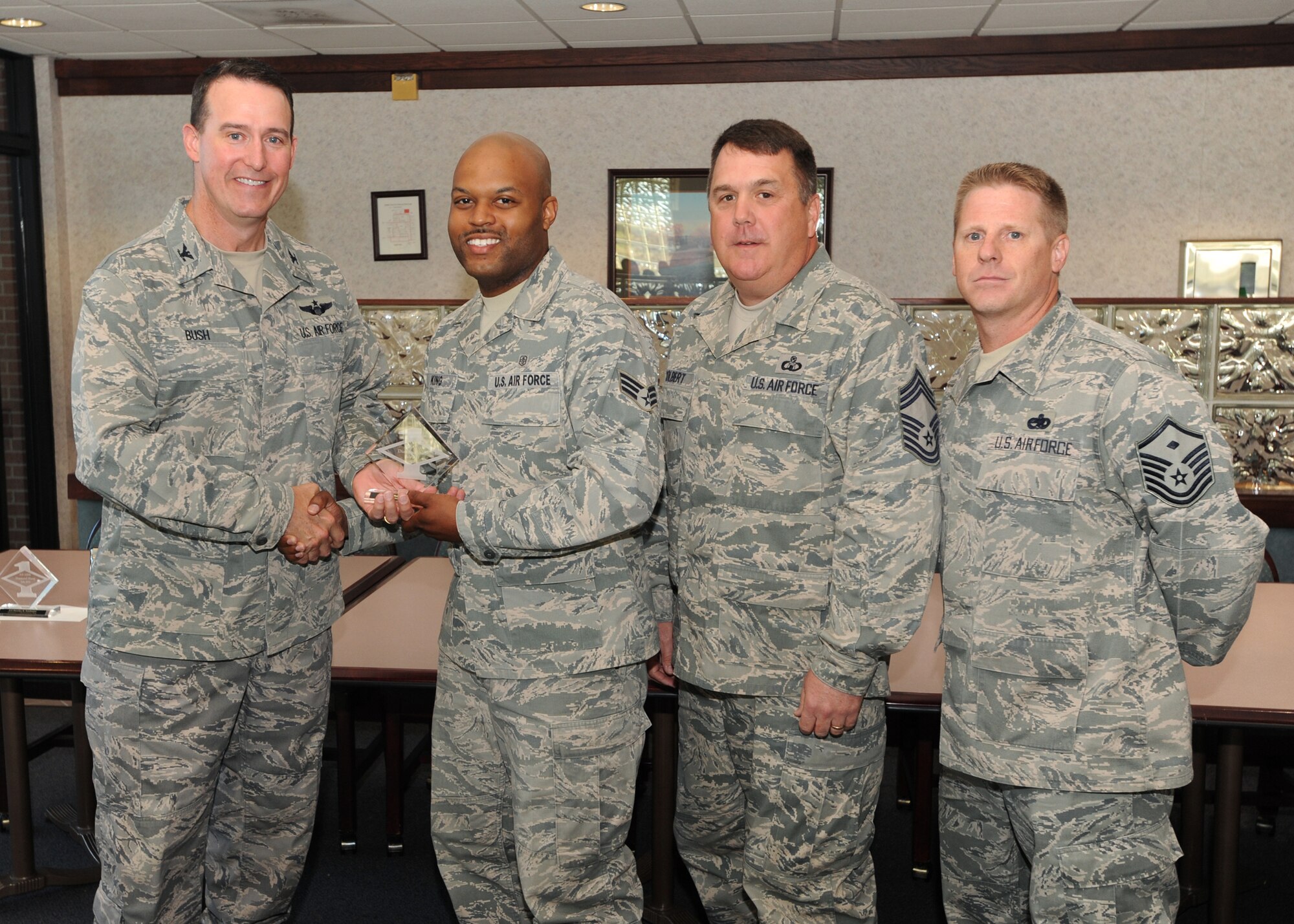 Col. Tim Bush, 319th Air Base Wing commander, presents Senior Airman Brison King, 319th Medical Operations Squadron, with a Diamond Sharp Award July 21 at Airey Dining Facility here, accompanied by Chief Master Sgt. Donald Colbert, 319th Operations Support Squadron, and Master Sgt. Harold Anderson, 319th MDOS first sergeant. The Diamond Sharp Award is given to those Airmen who epitomize service before self and strive for excellence at work and off duty. (U.S. Air Force photo by Staff Sgt. Suellyn Nuckolls)