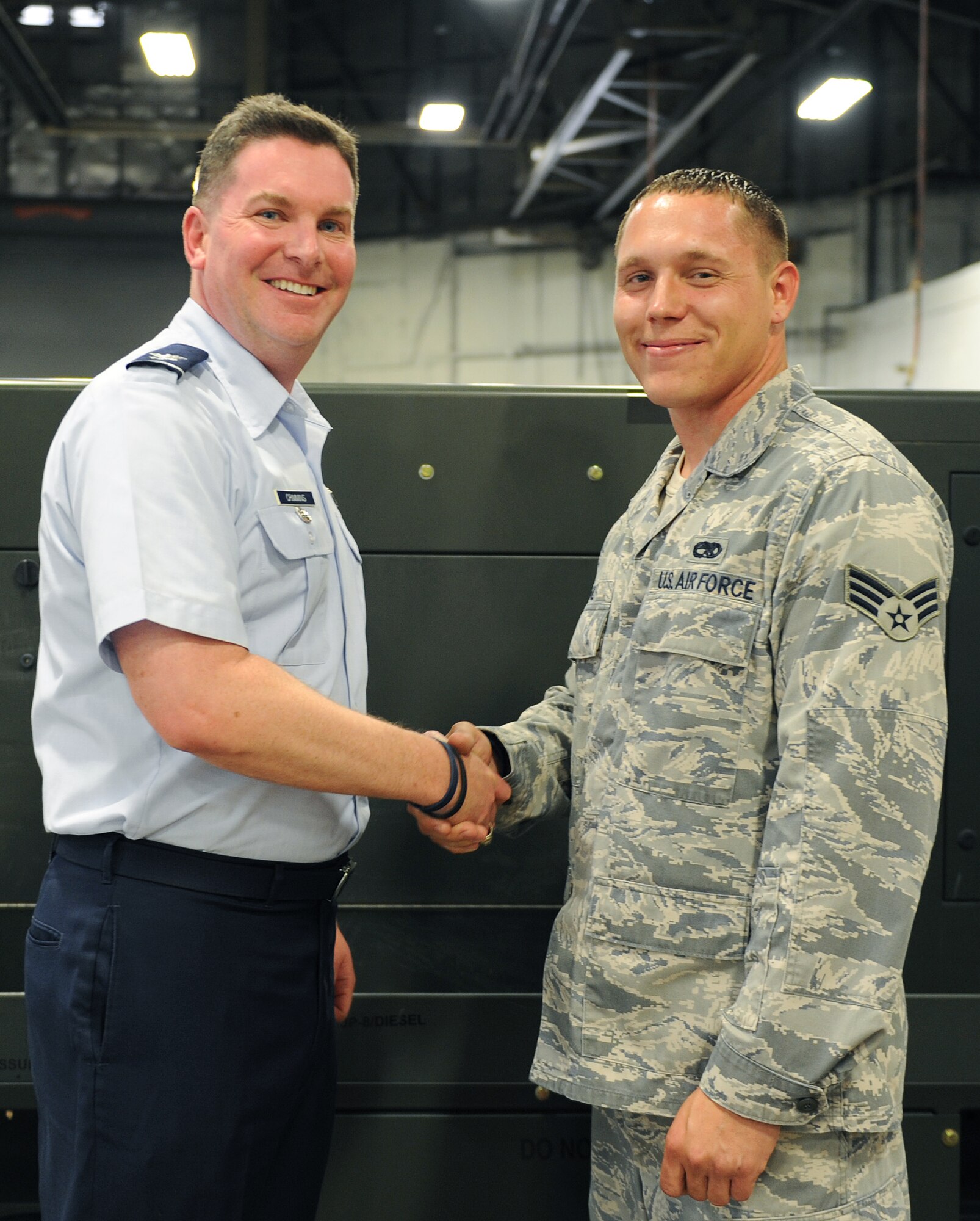 Col. Thomas Crimmins, 19th Airlift Wing vice commander, presents a commander’s coin to Senior Airman Joshua Wolf, a 19th Equipment Maintenance Squadron aerospace ground equipment production support section tool room custodian July 18, 2011, at Little Rock Air Force Base, Ark. Wolf skillfully analyzed the complex 19th EMS AGE support equipment inspection schedule. (U.S. Air Force photo by Airman 1st Class Ellora Remington)