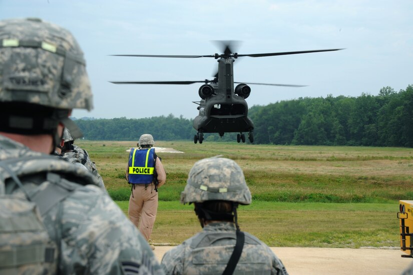 Defenders from the 11th Security Forces Squadron wait to board a Maryland Army National Guard CH-47 Chinook from Bravo Company, 3-126th General Support Aviation Battalion at Weide Army Airfeild, Va., during a training exercise at Davidson Army Airfeild on June 19.  The goal of the training was to familiarize servicemembers with procedures to enter, exit and defend helicopters in a deployed environment. (U.S. Air Force photo by Senior Airman Torey Griffith)