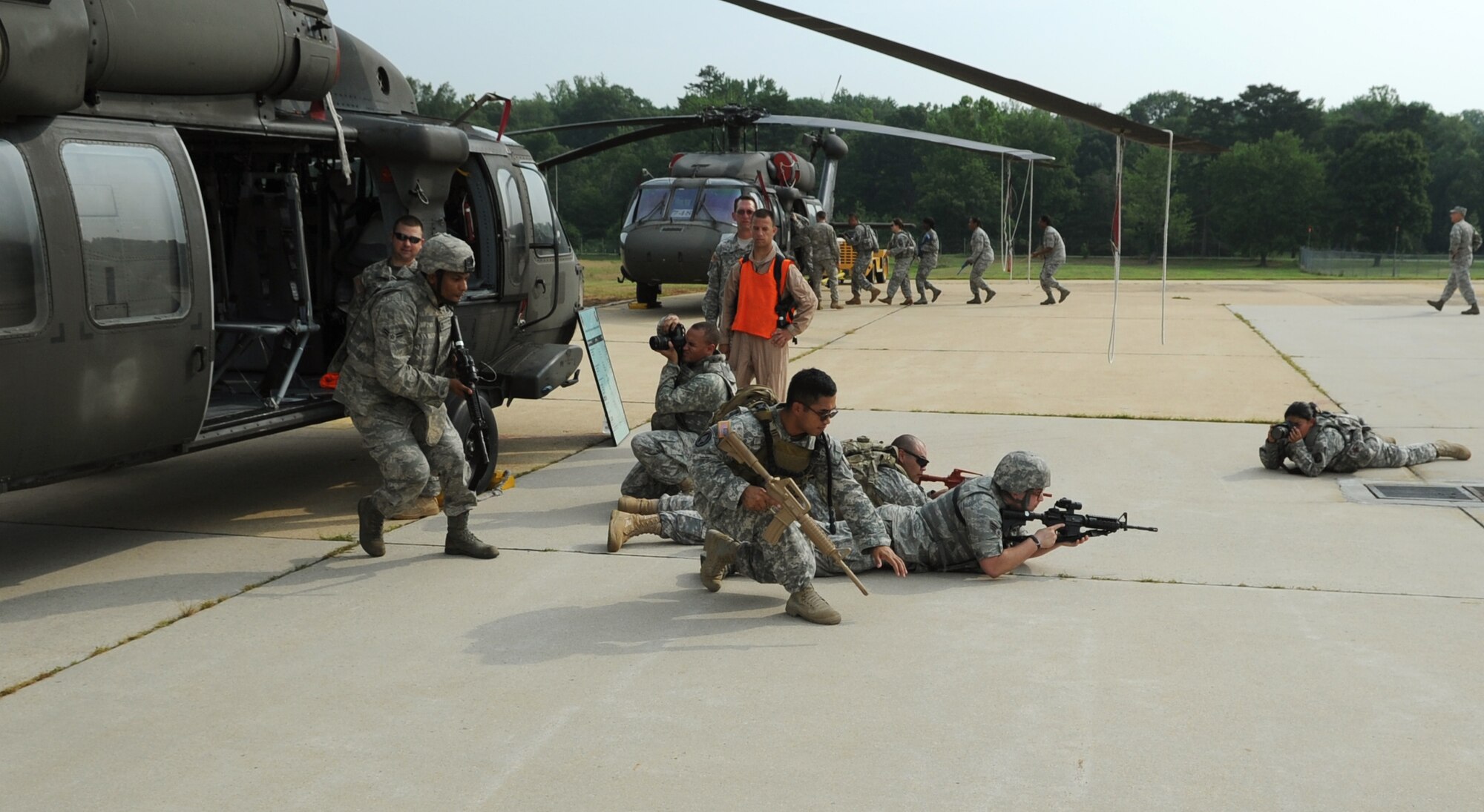Airmen from the 11th Wing Security Forces Squadron and Soldiers from the 55th Signal Company unload from a static CH-60 Black Hawk as they train for airborne operations at Davidson Airmy Airfeild, Va., July 19.  The training familiarized servicemembers with getting in to and out of helicopters in a deployed environment.  Combat Cameramen from the 55th Signal Company embedded with the Defenders as they trained combat operations as well. (U.S. Air Force photo by Senior Airman Torey Griffith)