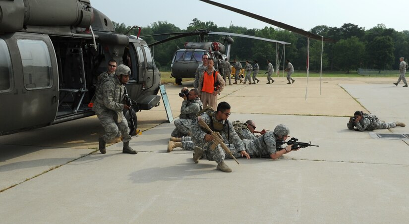Airmen from the 11th Wing Security Forces Squadron and Soldiers from the 55th Signal Company unload from a static CH-60 Black Hawk as they train for airborne operations at Davidson Airmy Airfeild, Va., July 19.  The training familiarized servicemembers with getting in to and out of helicopters in a deployed environment.  Combat Cameramen from the 55th Signal Company embedded with the Defenders as they trained combat operations as well. (U.S. Air Force photo by Senior Airman Torey Griffith)