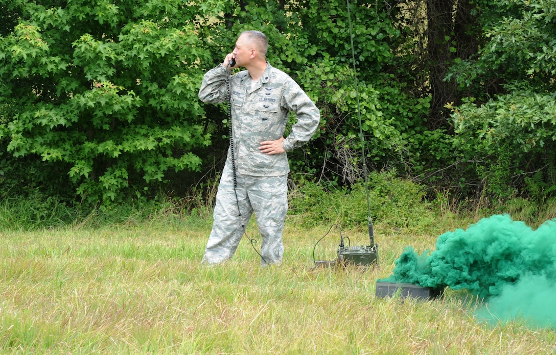 Lieutenant Colonel Kjäll Gopaul, Director of Joint and Air Staff Liason at the LeMay Center for Doctrine Development and Education at the Pentagon, communicates with a CH-47 Chinook helicopter dropping troops for combat exercises at the landing zone near Brandywine, Md., June 19.  The training included Members of the 89th Communications Squadron from Joint Base Andrews, 579th Medical Group from Joint Base Annacostia-Bolling, and the 55th Signal Company from Fort Meade, Md. (U.S. Air Force photo by Senior Airman Torey Griffith)