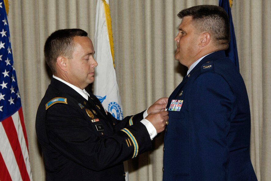 HANSCOM AIR FORCE BASE, Mass. – Army Col. Edward J. Fish, U.S. Army Central Clearance Facility commander (left), pins a medal on Col. Jeffrey R. MacEachron, 66th Air Base Group Inspector General, during his retirement ceremony July 8. Lt. Col. Scott Pierce will take over as Hanscom’s Inspector General. (U.S. Air Force photo by Linda LaBonte Britt) 