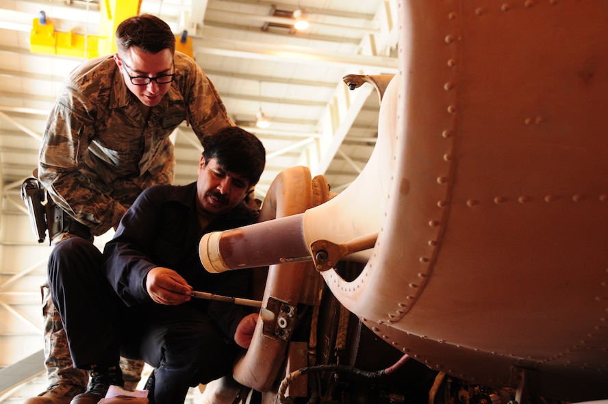 Master Sgt. Dave Penisten verifies a compressor blade with 1st Lt. Ahmad Shah July 9, 2011, at the Afghan air force compound in Kabul, Afghanistan. Penisten is a coalition adviser deployed to the 440th Air Expeditionary Advisory Squadron, and. Lieutenant Shah is an Afghan air force maintainer. (U.S. Air Force photo/Senior Airmen Amber Williams)