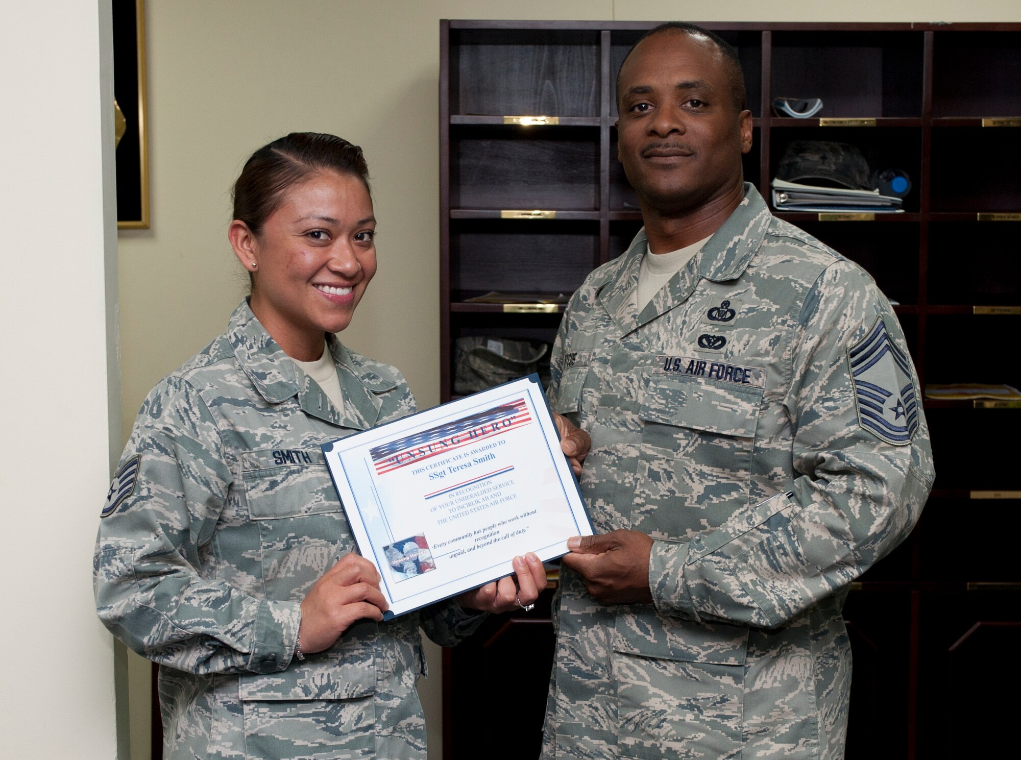 Staff Sgt. Teresa Smith, 39th Air Base Wing executive assistant to the command chief, receives the Unsung Hero Award from Chief Master Sgt. Roderick Dycus, 39th Mission Support Group superintendent, July 20, 2011, at Incirlik Air Base, Turkey. The Top 3 presents the Unsung Hero Award monthly to an Airman presenting superior job performance and exceptional leadership. (U.S. Air Force photo by Airman 1st Class Clayton Lenhardt/Released)