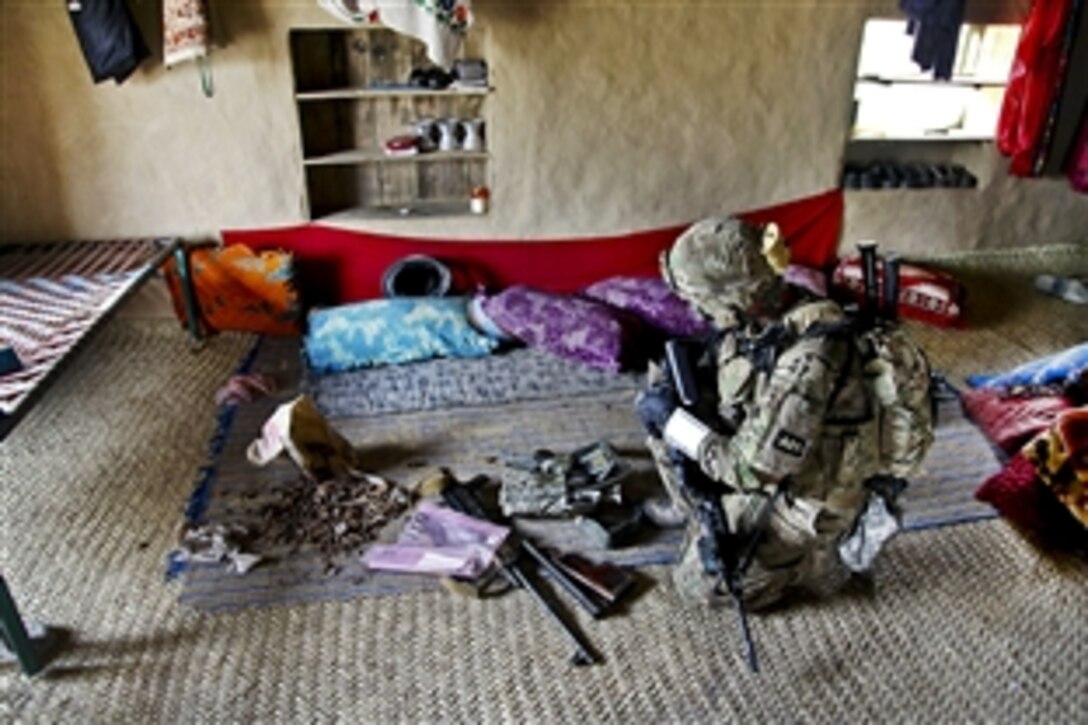 U.S. Army Staff Sgt. Jess Mckinney looks at evidence during a mission in Bowri Tana, Khowst province, Afghanistan, July 17, 2011. McKinney is assigned to the 1st Infantry Division's 1st Battalion, 6th Field Artillery Regiment, 3rd Brigade Combat Team.