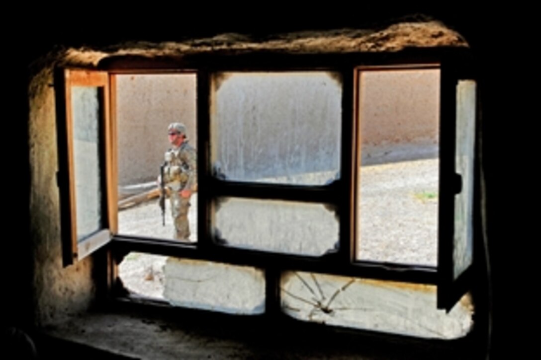 U.S. Army Sgt. Michael Lovett secures a home during a meeting with village elders and members of Provincial Reconstruction Team Zabul in Arghandab, Afghanistan, July 20, 2011. Lovett is a team leader assigned to Provincial Reconstruction Team Zabul's security force and is deployed from the Massachusetts National Guard.