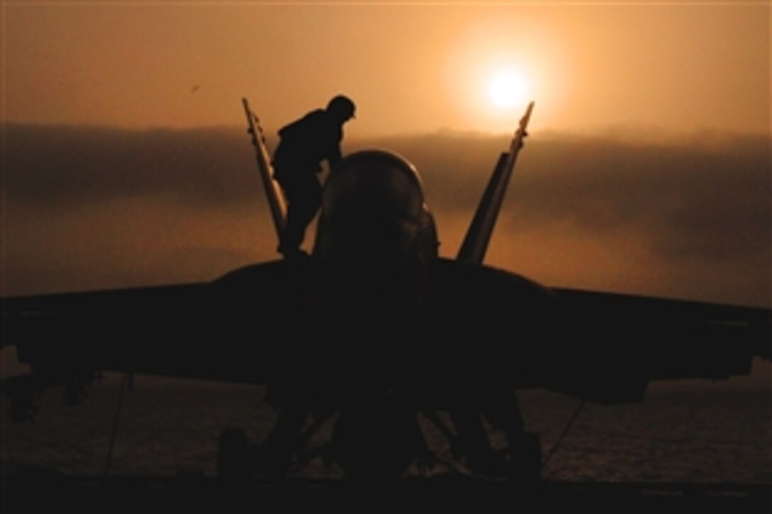 U.S. Navy Seaman Kenneth Klingaman cleans the canopy of an F/A-18E Super Hornet on the flight deck of the USS George H.W. Bush in the Arabian Sea, July 20, 2011. The George H.W. Bush is deployed in support of maritime security operations and theater security cooperation efforts in the U.S. 5th Fleet area of responsibility on its first operational deployment. Klingaman is an aviation machinist's mate airman. 