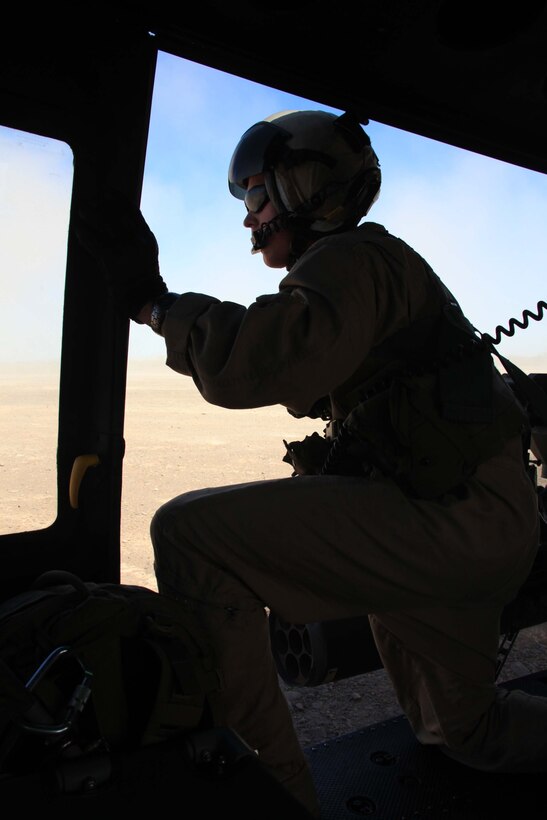Sgt. Lucas W. Anderson, HMLA-773 crew chief, checks for target locations out of a UH-1N Huey helicopter during a close air support exercise July 21. The mission was one of many during Operation Javelin Thrust, which offered reserve Marines an opportunity to prepare for a deployed environment.