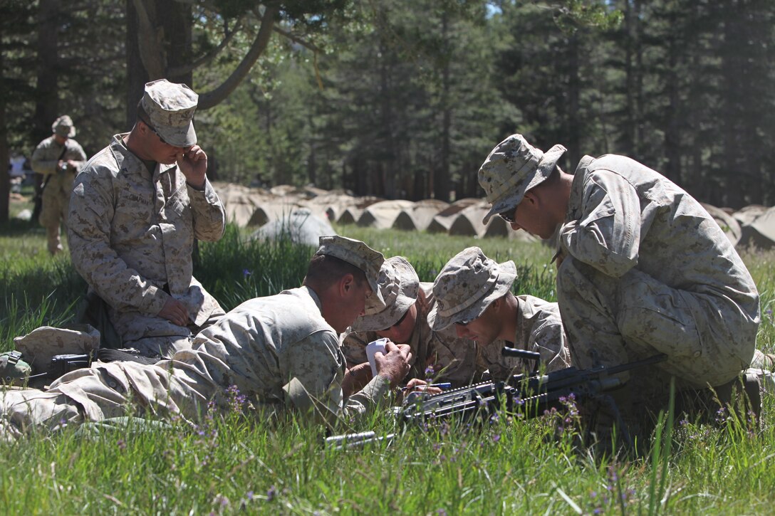 Marines with Company K, 3rd Battalion, 23rd Marine Regiment, work together to mark all their tactical points on their map before during a land navigation course part of Operation Javelin Thrust, July 21.