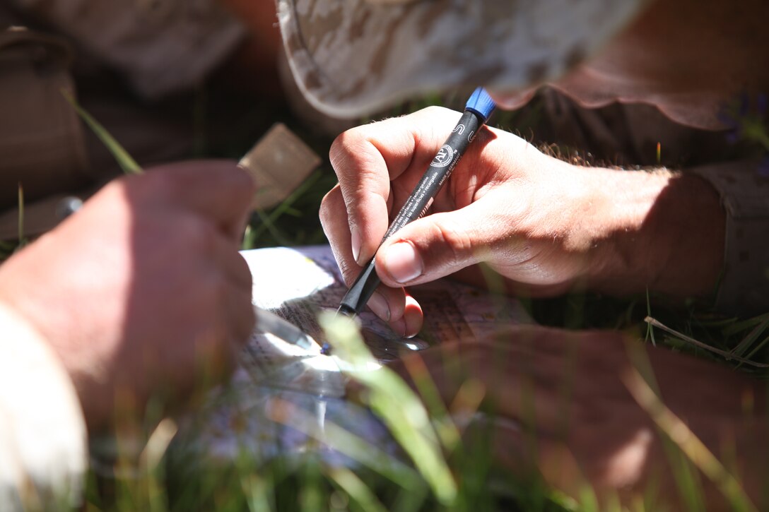 Marines of Company K, 3rd Battalion, 23rd Marine Regiment mark tactical points on a map as part of a land navigation training during Operation Javelin Thrust July 21.