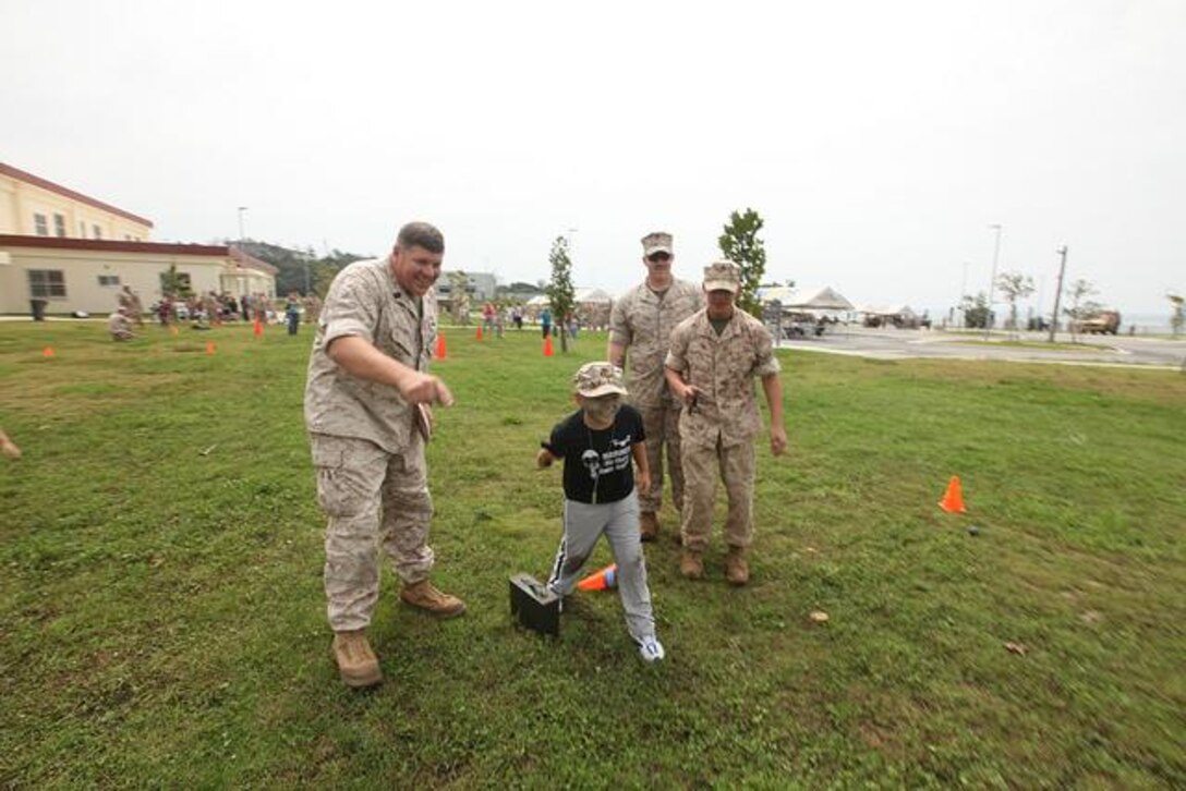 Conrad Croft, 8, throws a simulated grenade toward his objective while conducting a modified Combat Fitness Test
