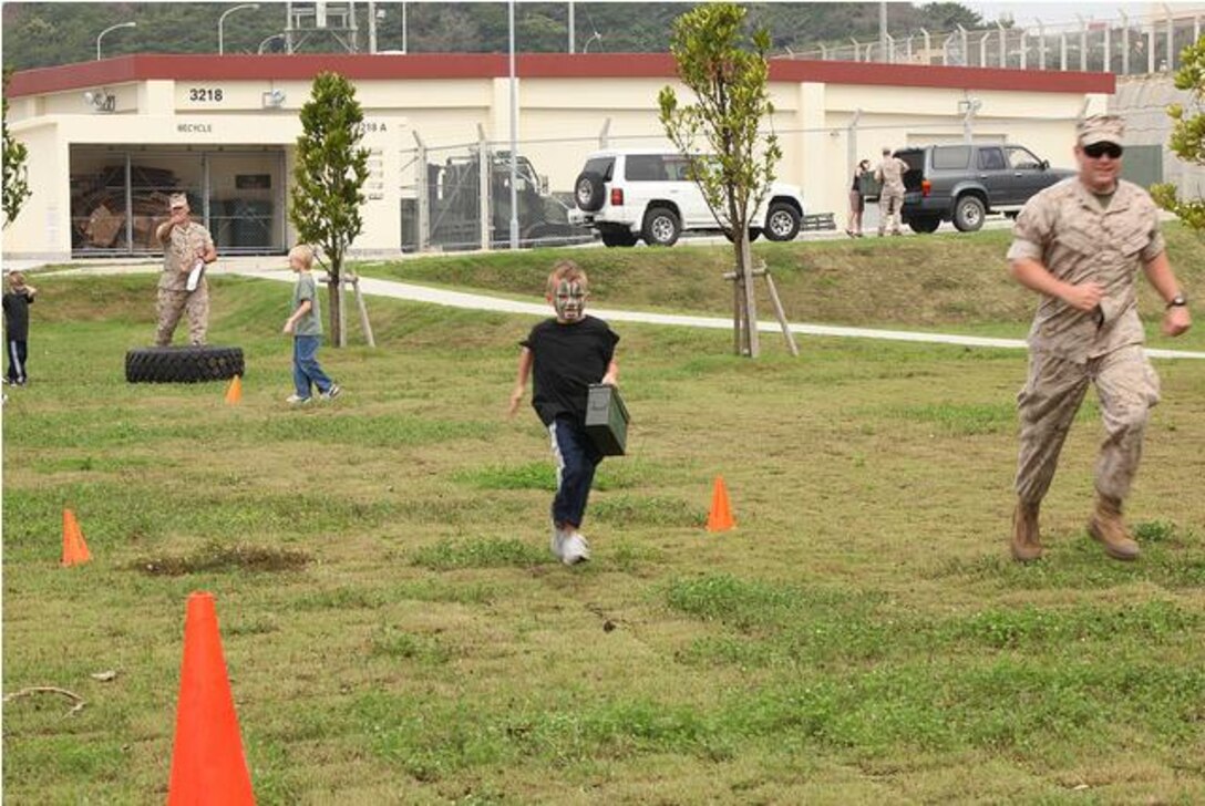 Logan Kennedy, 7, runs with an ammunition can during a modified Combat Fitness Test at 3rd Reconnaissance Battalion’s Family Fun Day here May 13.