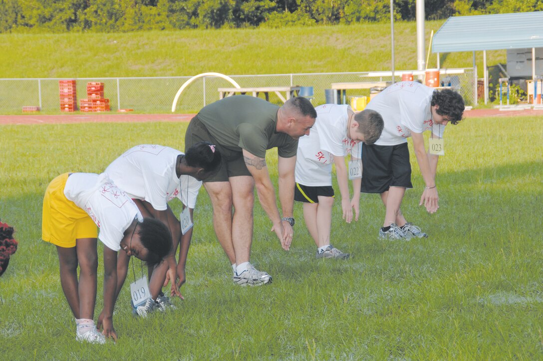 Chief Warrant Officer 2 Stephen Sutton stretches with Kids on the Move participants at Albany State University, July 22.