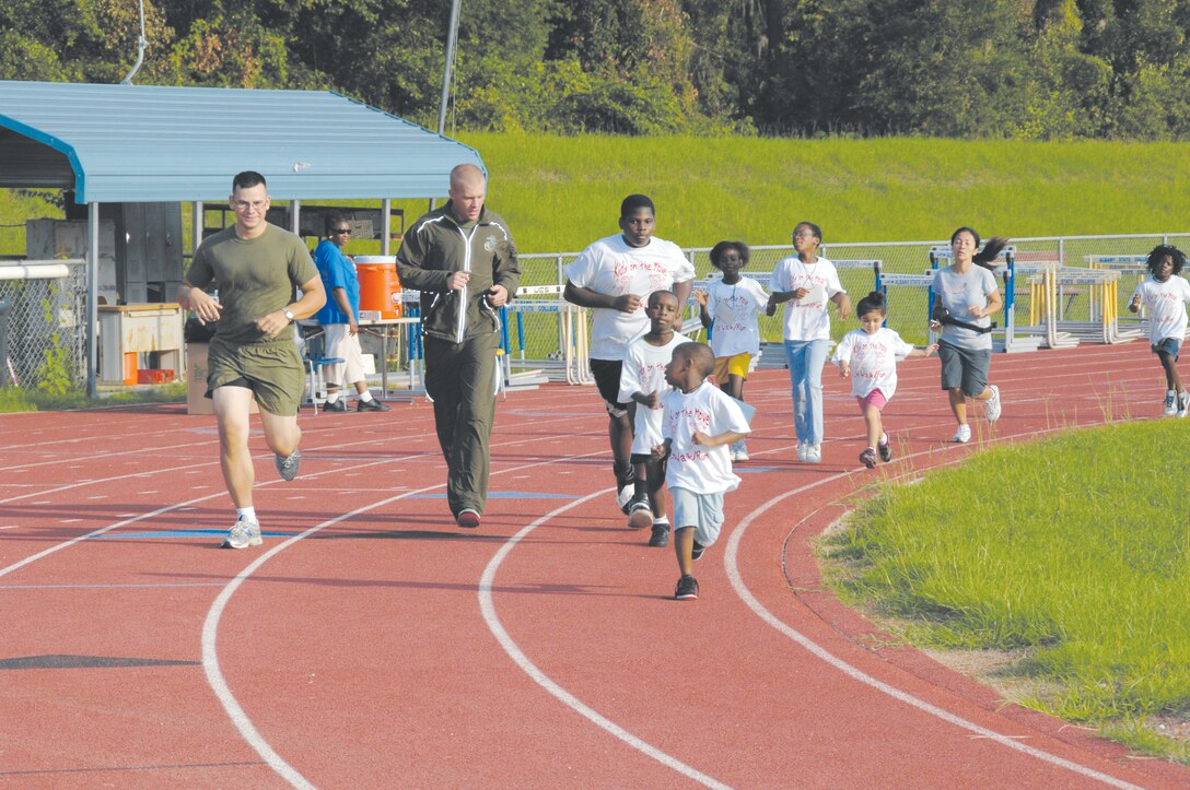 Marines run with a group of youngsters during the seventh annual Kids on the Move 5K race at Albany State University, July 22. The event is designed to promote health and wellness among local youth. Nearly 100 children, ages 2-16, participated in the race.