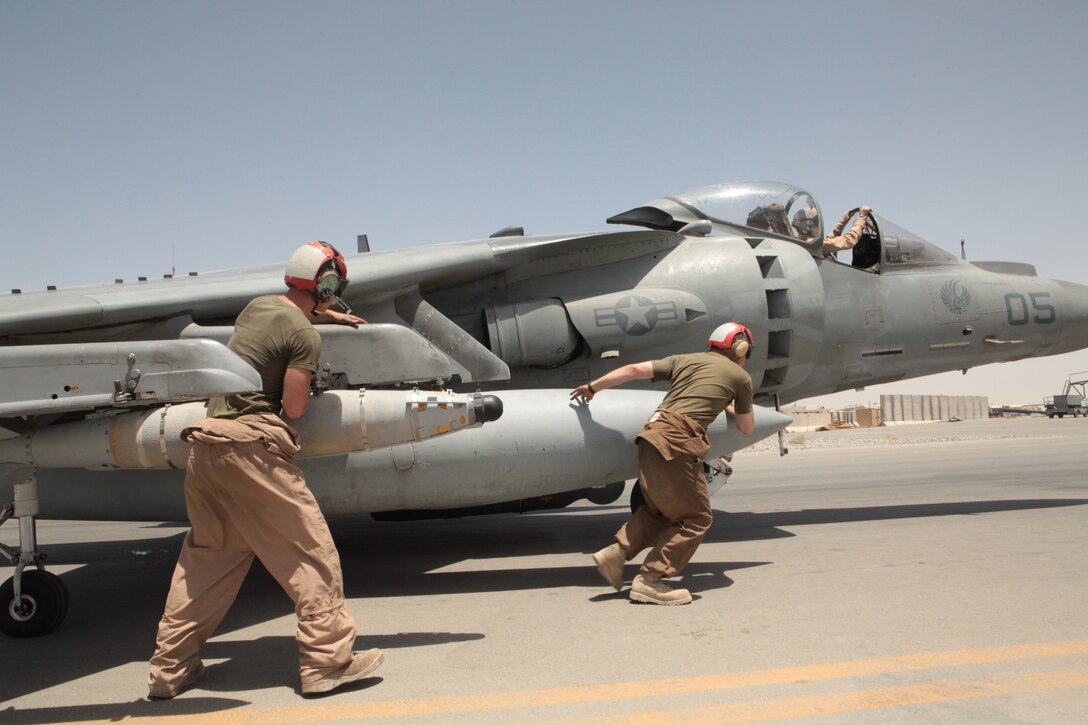 Marine Attack Squadron 513 ordnance technicians Cpl. Timothy Johnson, a Huntsville, Texas, native, and Cpl. David Ryan, a San Jose, Calif., native, arm one of the squadron’s AV-8B Harriers for a combat mission on the flightline of Kandahar Airfield, Afghanistan, July 22.