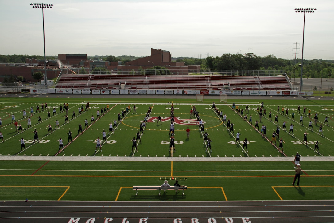 Drill instructors and Marines with Recruiting Station Twin Cities lead more than 130 athletes in warm-up exercises at Maple Grove Senior High School during the Minneapolis Junior Rank Diamond Flight Football Camp July 22. For additional imagery from the event, visit www.facebook.com/rstwincities.