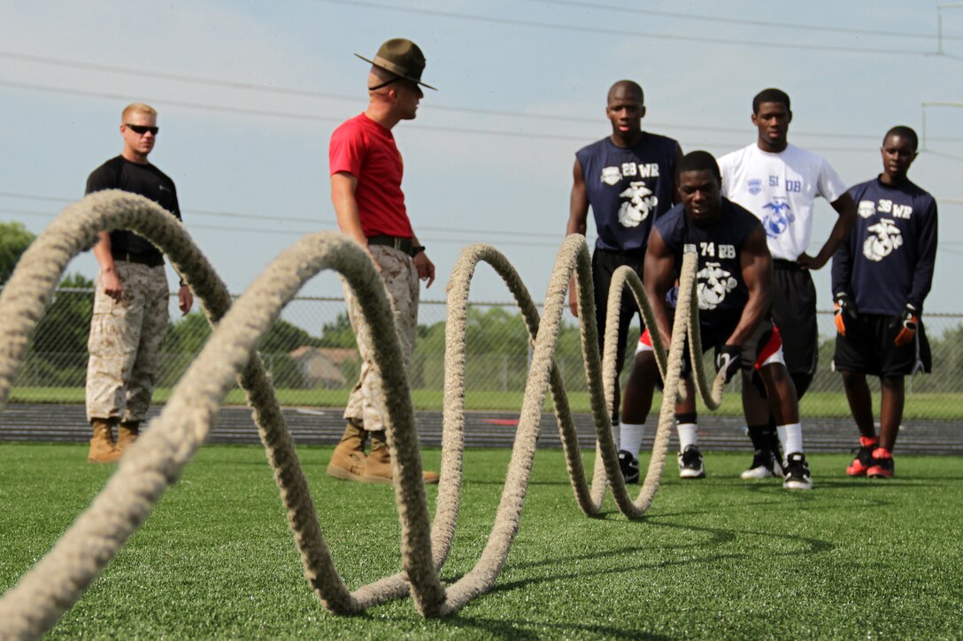 Football players conduct conditioning exercises under the close supervision of Marines at Maple Grove Senior High School during the Minneapolis Junior Rank Diamond Flight Football Camp July 22. More than 130 athletes attended three-day camp. For additional imagery from the event, visit www.facebook.com/rstwincities.